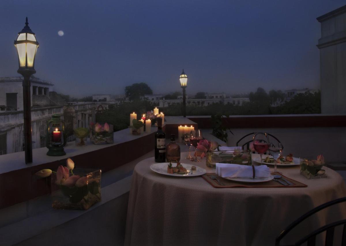 a balcony with two tables with candles and lights at Ambassador, New Delhi - IHCL SeleQtions in New Delhi a balcony with two tables with candles and lights at Ambassador, New Delhi - IHCL SeleQtions in New Delhi