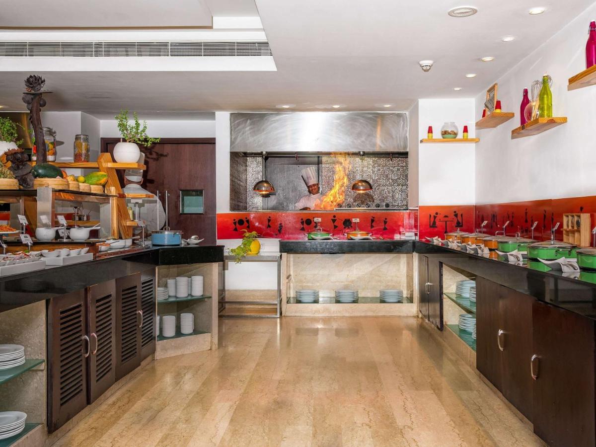 a large kitchen with wooden floors and red accents at Mercure Hyderabad KCP Banjara Hills, An Accor Hotel in Hyderabad