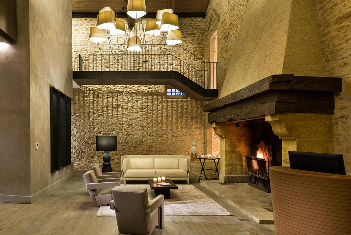 un salon avec un canapé et une cheminée dans l'établissement Château de Bagnols, à Bagnols