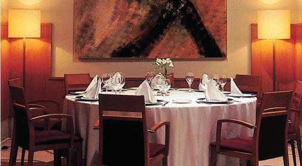 Un comedor con una mesa y sillas y un cuadro. en Lobios Caldaria Hotel Balneario, en Bubaces 50 fotos más