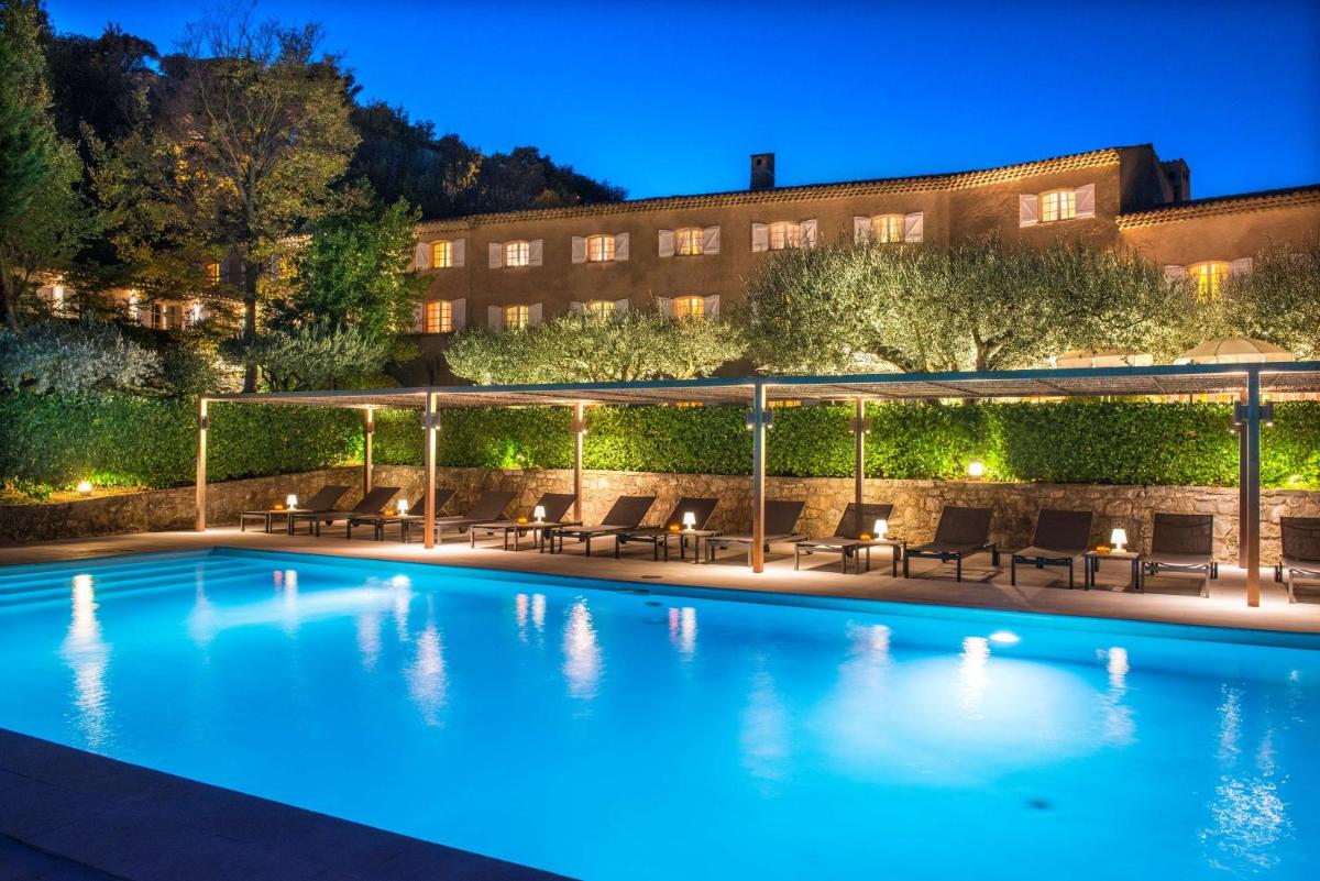 une piscine avec des chaises et un bâtiment en arrière-plan dans l'établissement La Bastide du Calalou Hotel & Spa, BW Signature Collection, à Moissac-Bellevue