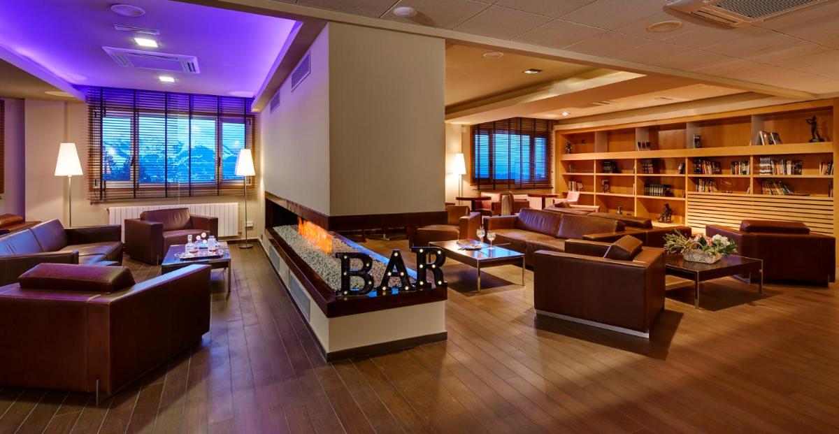 un gran vestíbulo con sofás y chimenea en Hotel & Spa La Collada, en Toses
