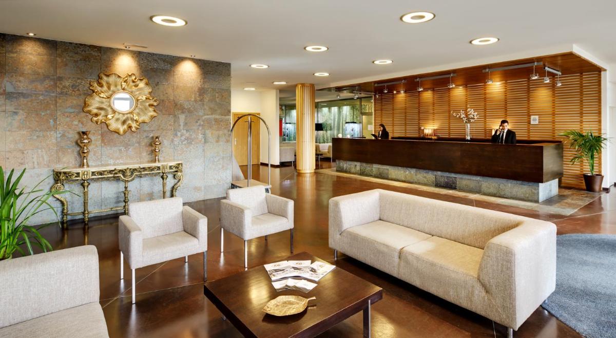 Un vestíbulo con un sofá y sillas y una mesa. en Hotel & Spa La Collada, en Toses
