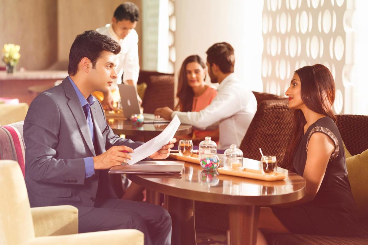 a group of people sitting at a table in a restaurant at Crowne Plaza Ahmedabad City Centre by IHG in Ahmedabad