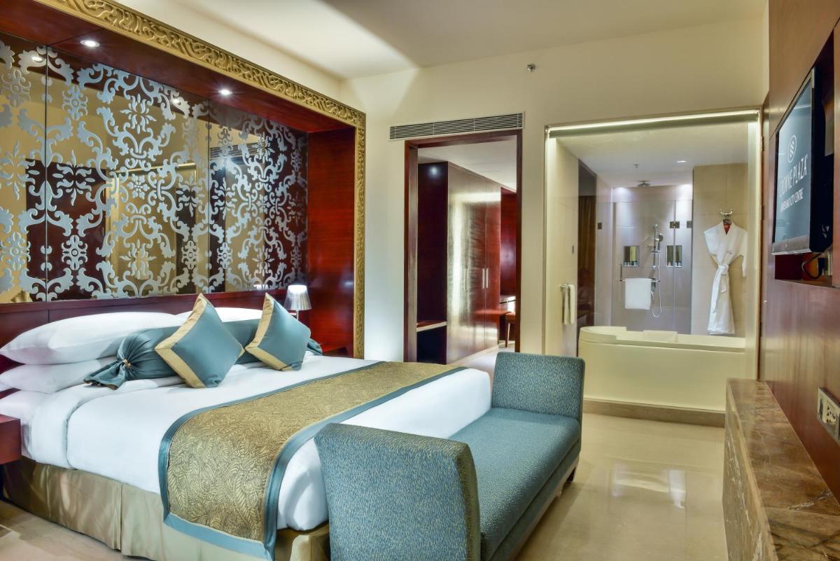 a hotel room with a bed and a chair at Crowne Plaza Ahmedabad City Centre by IHG in Ahmedabad