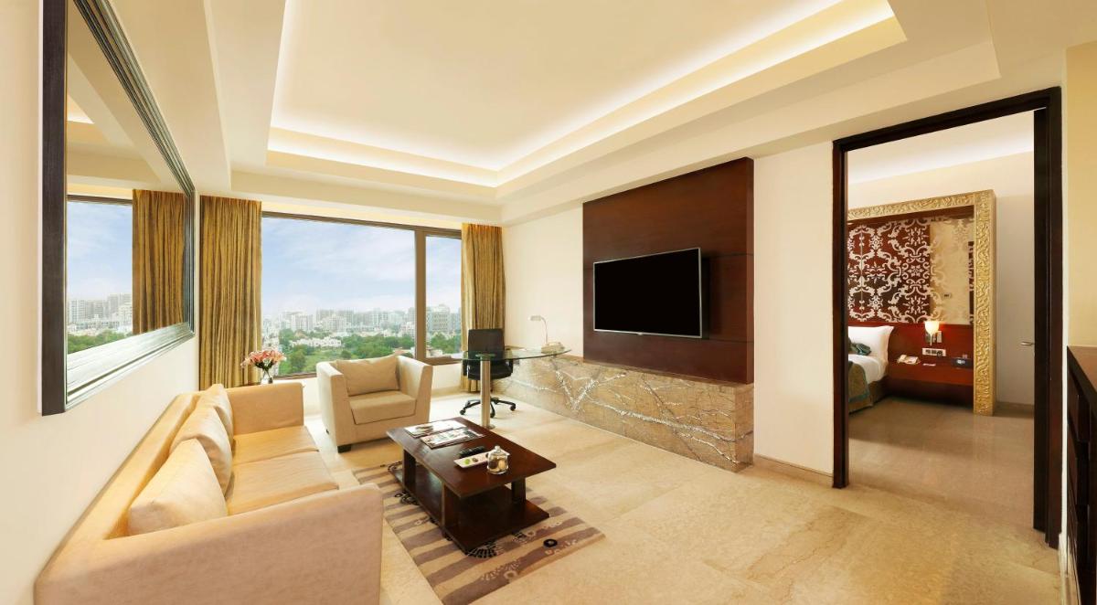 a living room with a couch and a tv at Crowne Plaza Ahmedabad City Centre by IHG in Ahmedabad