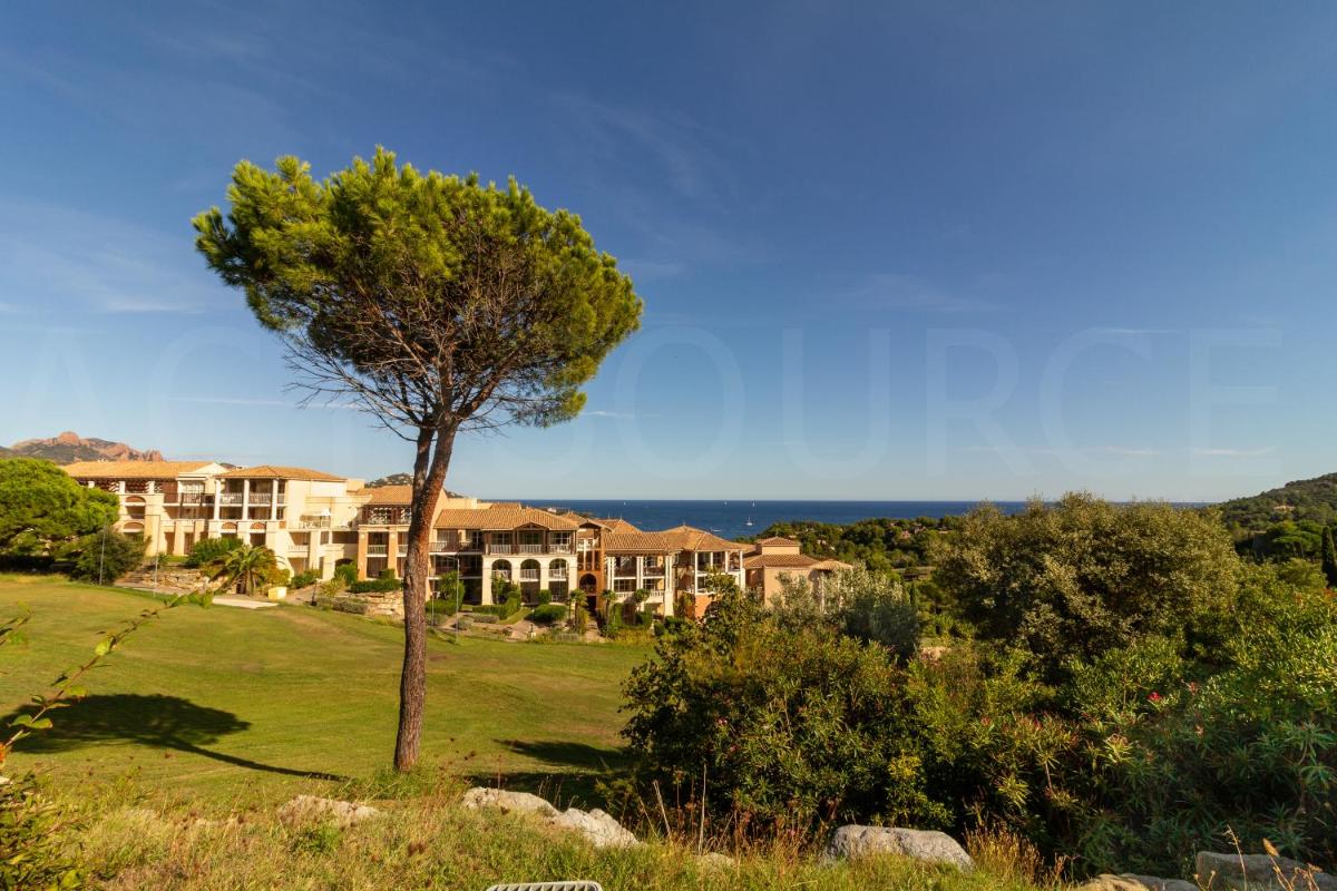une maison sur une colline avec un arbre au premier plan dans l'établissement Cap Estérel by Actisource, à Agay