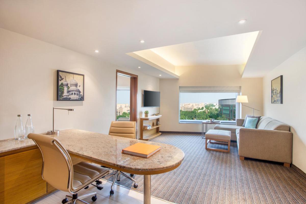 a living room with a table and a couch at Hyatt Place Hyderabad Banjara Hills in Hyderabad