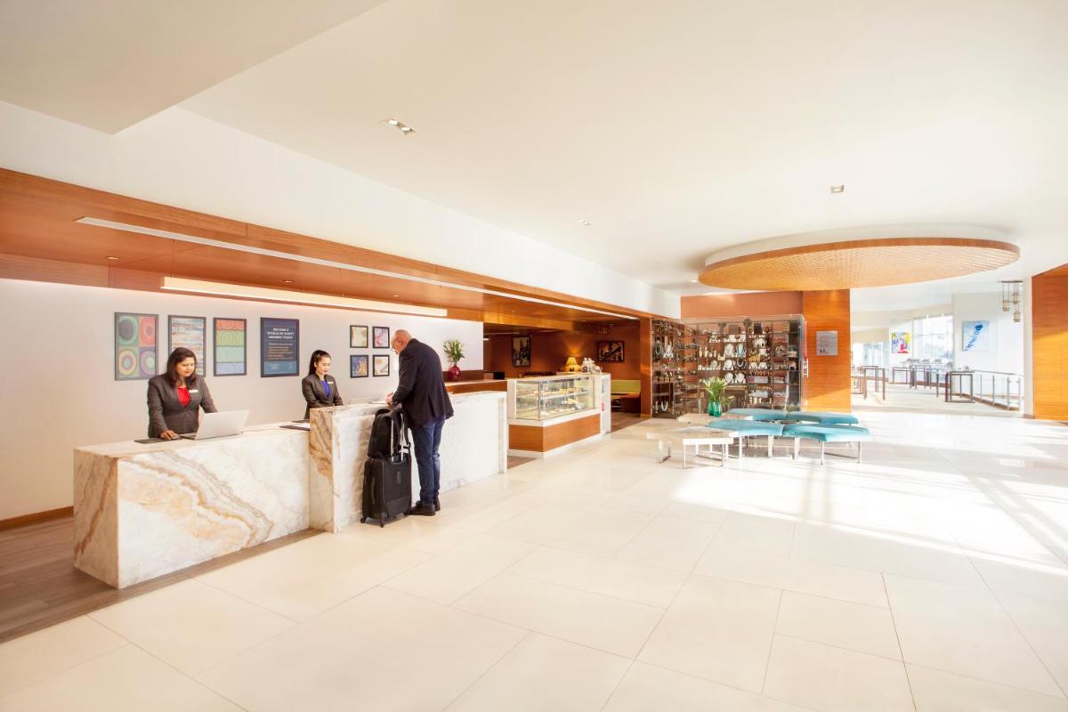 two people standing at a counter in a lobby at Hyatt Place Hyderabad Banjara Hills in Hyderabad