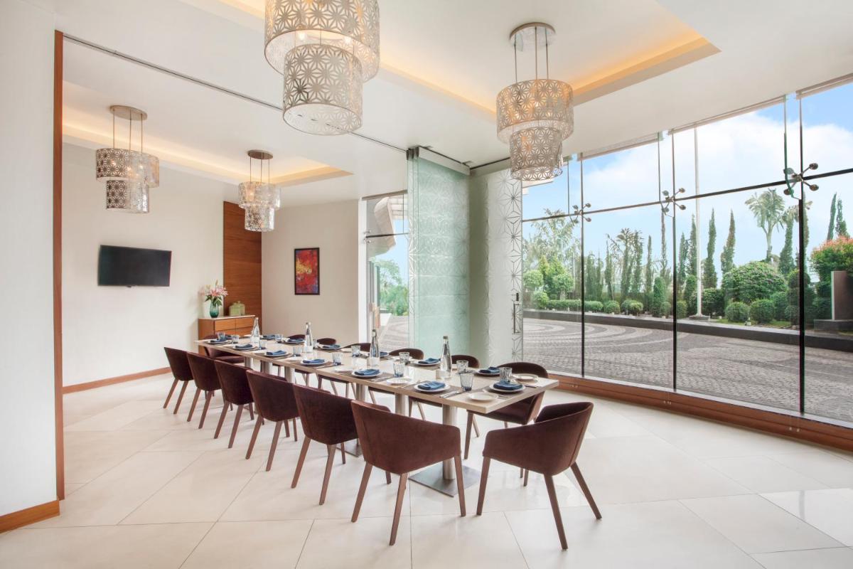 a large dining room with a long table and chairs at Hyatt Place Hyderabad Banjara Hills in Hyderabad