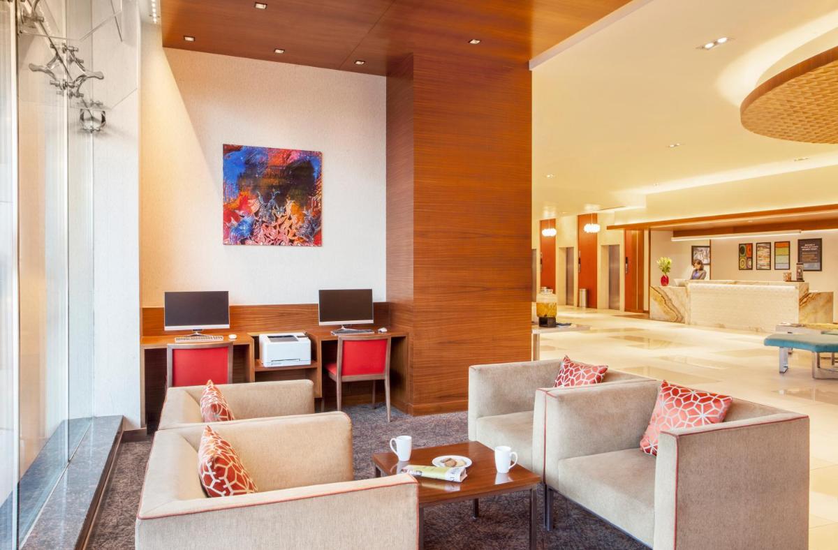 a lobby of a hotel with chairs and a table at Hyatt Place Hyderabad Banjara Hills in Hyderabad