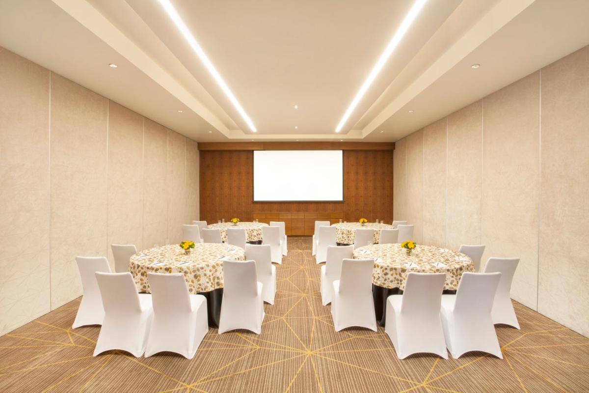 a conference room with white tables and white chairs at Hyatt Place Hyderabad Banjara Hills in Hyderabad