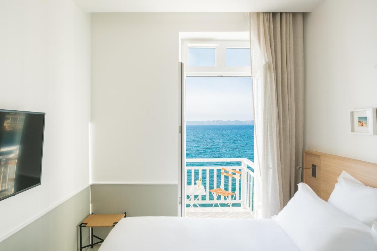 une chambre avec une fenêtre avec vue sur l'océan dans l'établissement Les Bords De Mer, à Marseille