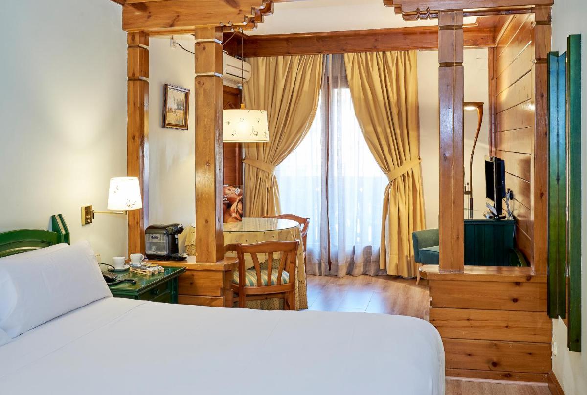 Un dormitorio con una cama, un escritorio y una mesa. en Hotel Grèvol Spa, en Camprodon