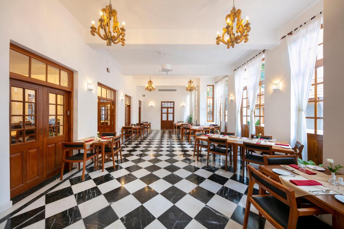 a restaurant with a black and white checkered floor at Grand Hotel D'Europe in Puducherry