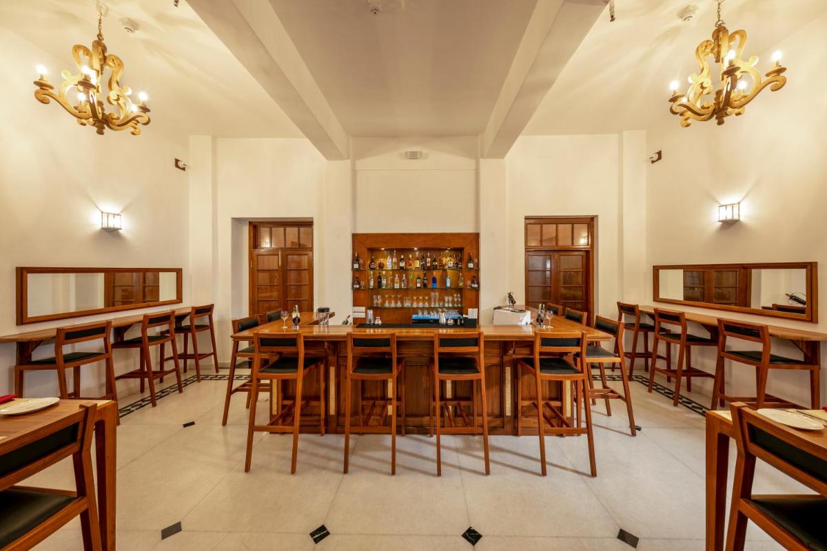 a large dining room with wooden tables and chairs at Grand Hotel D'Europe in Puducherry