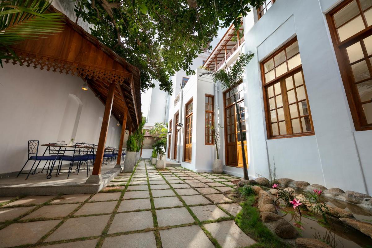 a courtyard of a house with a table and chairs at Grand Hotel D'Europe in Puducherry