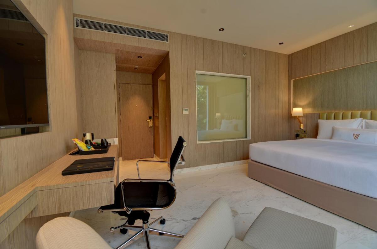 a bedroom with a bed and a desk and a computer at Vividus in Bengaluru a bedroom with a bed and a desk and a computer at Vividus in Bengaluru