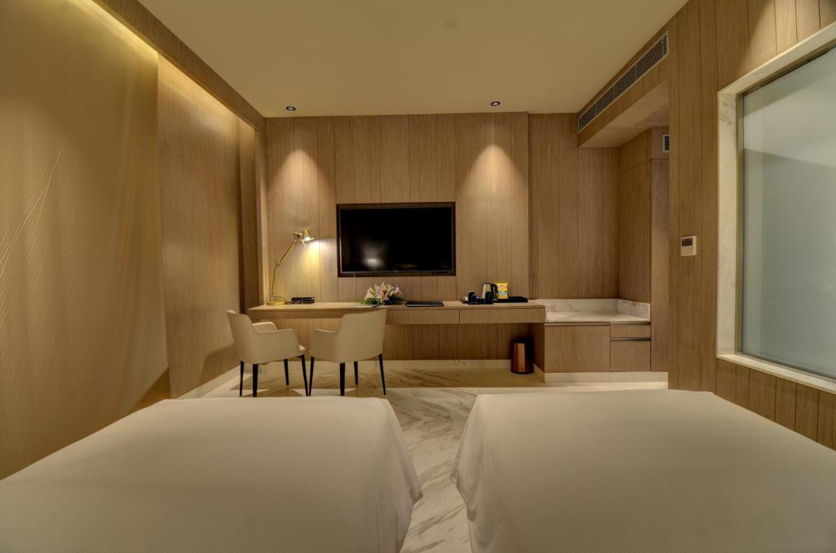 a bedroom with two beds and a desk with a television at Vividus in Bengaluru a bedroom with two beds and a desk with a television at Vividus in Bengaluru