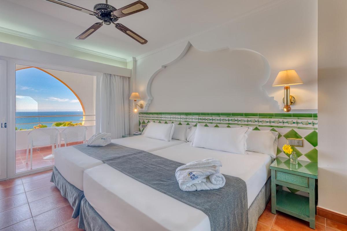 Un dormitorio con una cama con vista al mar. en Playacálida, en Almuñécar