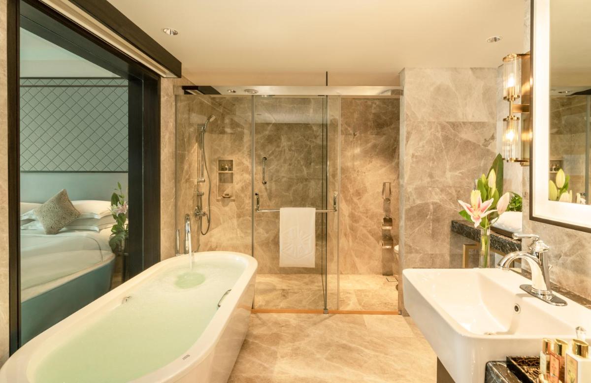 a bathroom with a tub and a sink and a shower at Taj Coromandel in Chennai