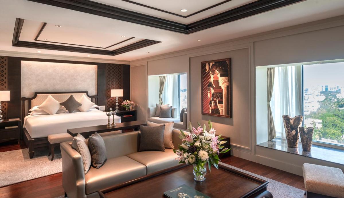 a bedroom with a bed and a living room with a couch at Taj Coromandel in Chennai