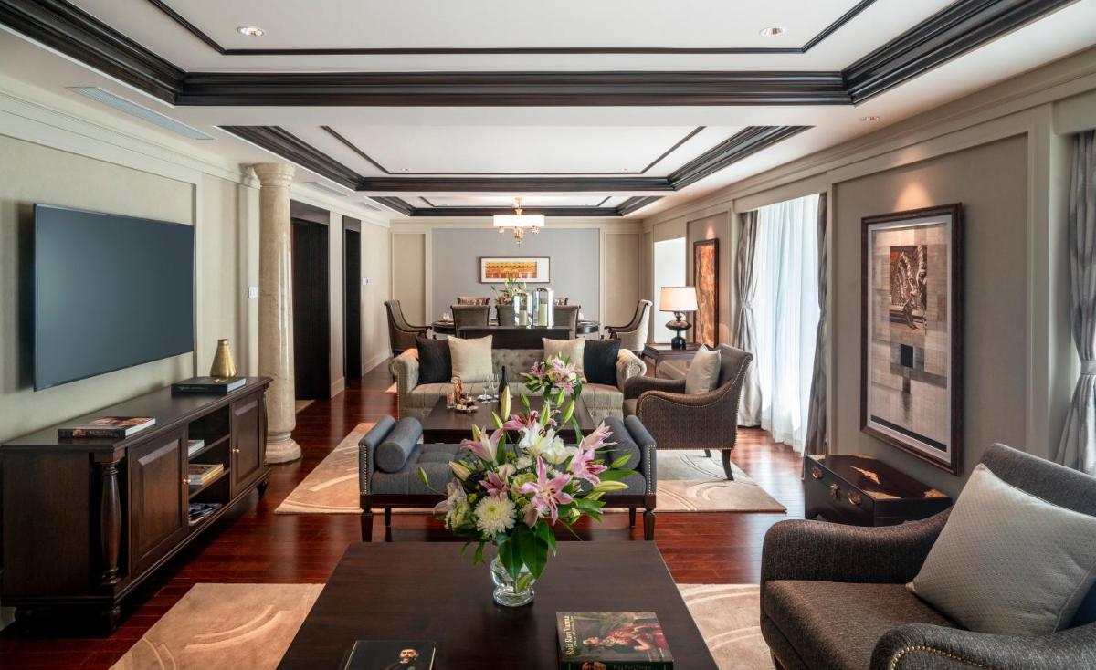 a living room filled with furniture and a table with flowers at Taj Coromandel in Chennai