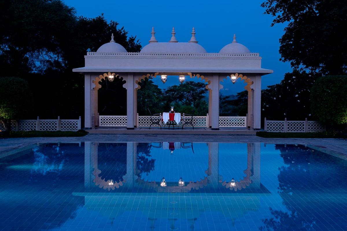 a gazebo with a table in it next to a pool at Trident Udaipur in Udaipur