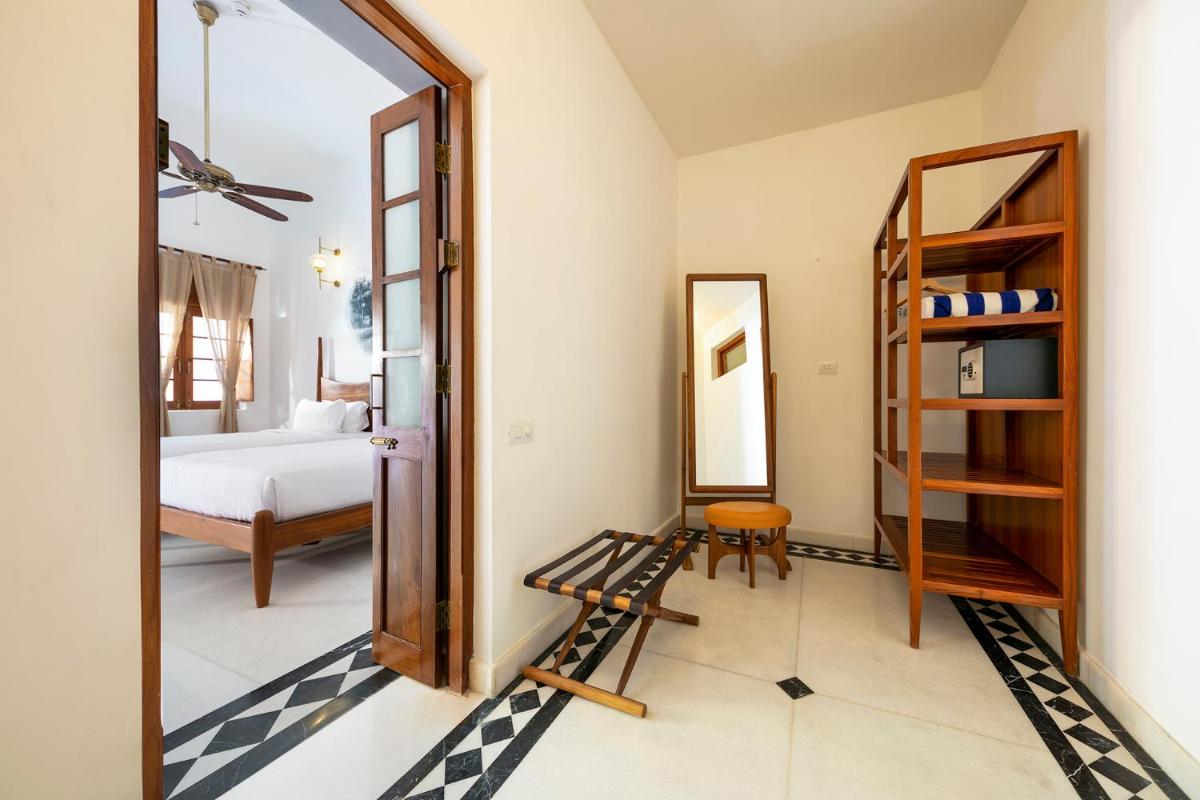a room with a mirror and a bedroom with a bed at Grand Hotel D'Europe in Puducherry