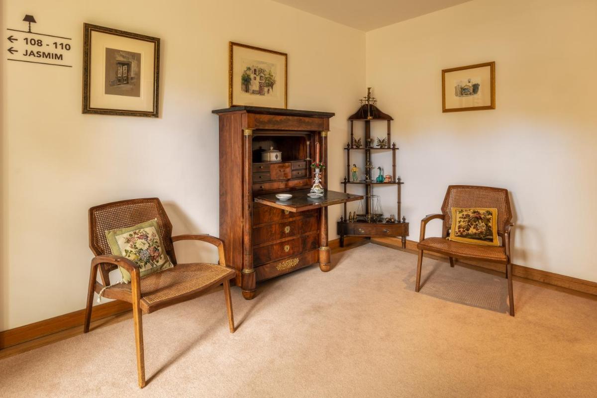 uma sala de estar com duas cadeiras e um armário em Quintinha Sao Joao Hotel & Spa no Funchal