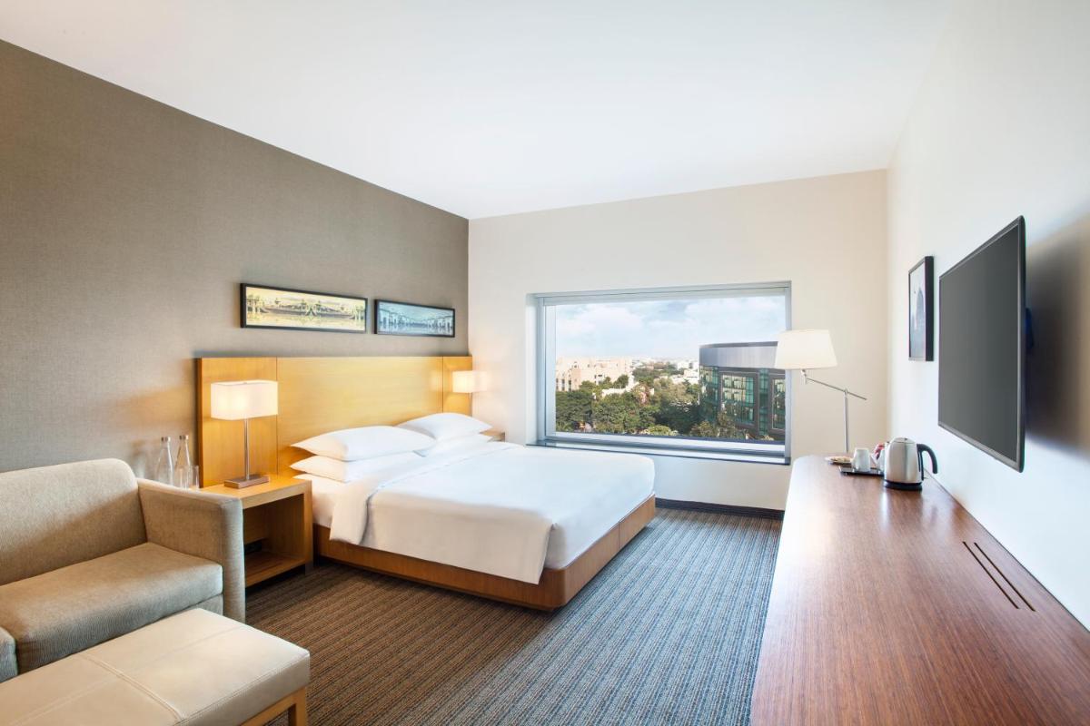 a hotel room with a bed and a window at Hyatt Place Hyderabad Banjara Hills in Hyderabad