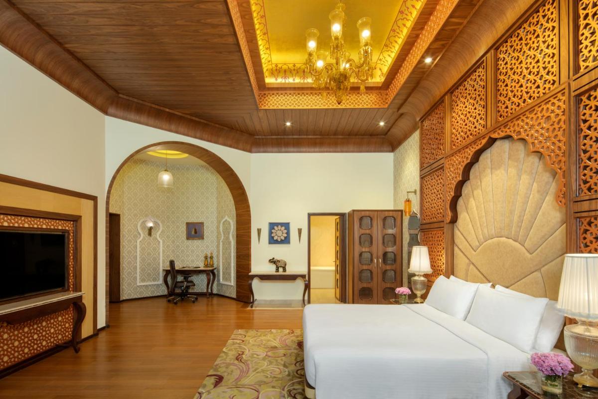 a living room with a white bed and a chandelier at Radisson Jodhpur in Jodhpur