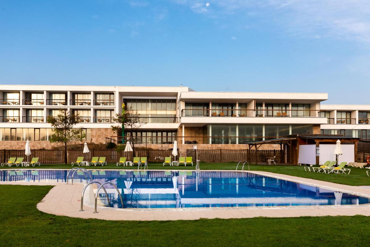 un hotel con piscina frente a un edificio en Parador de El Saler, en El Saler