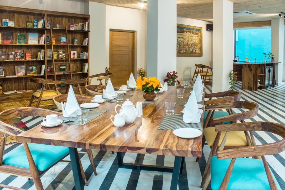 a large wooden table with paper boats on it in a library at Brij Nest, Jaipur - An All Suite Boutique Hotel in Jaipur