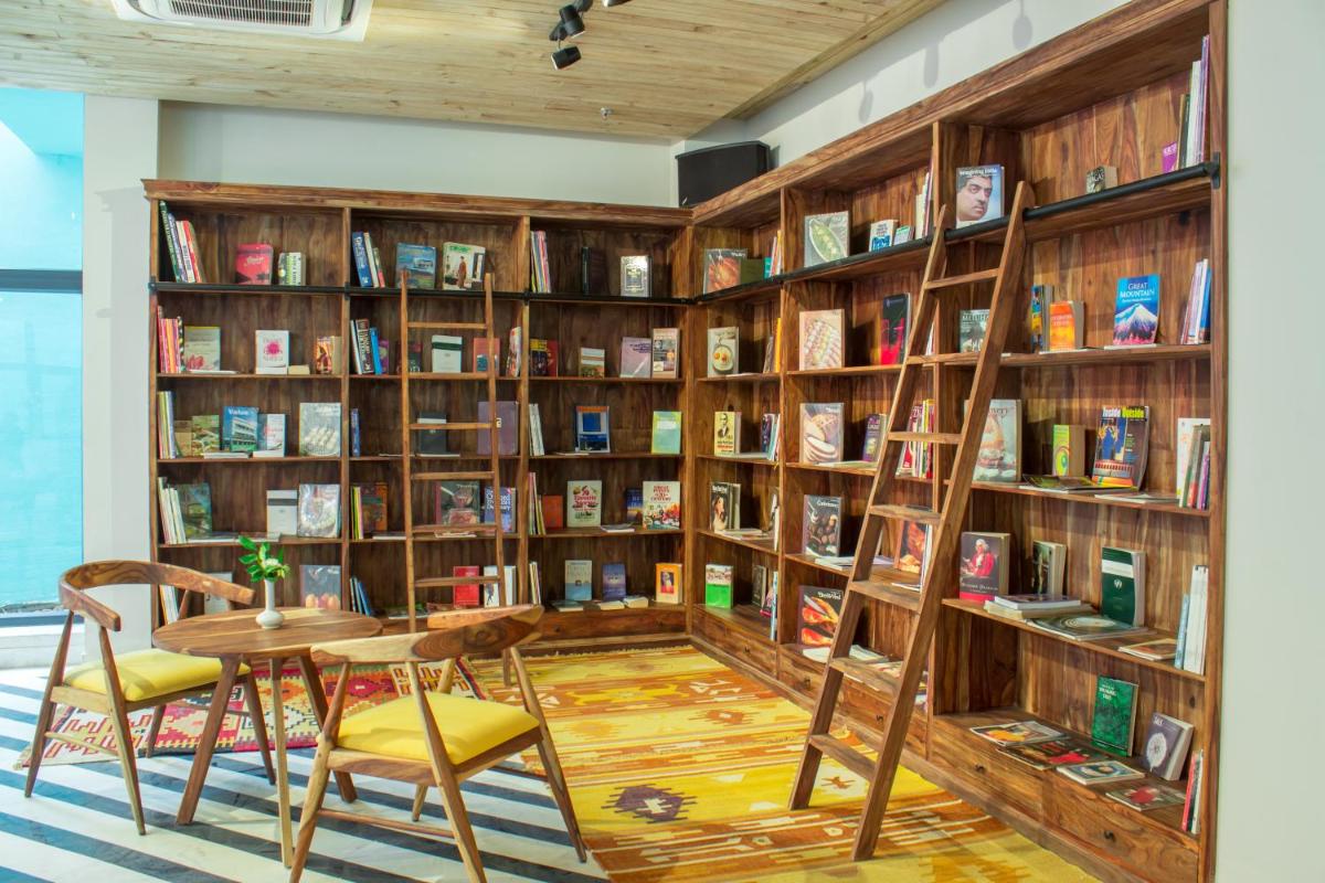 a library with wooden shelves filled with books at Brij Nest, Jaipur - An All Suite Boutique Hotel in Jaipur