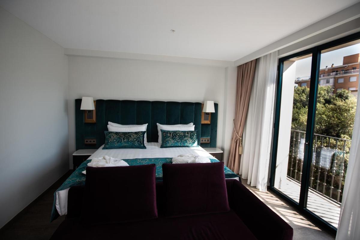 Un dormitorio con una cama y una ventana grande. en Boutique Hotel Élke Spa Superior, en Sant Feliu de Guíxols