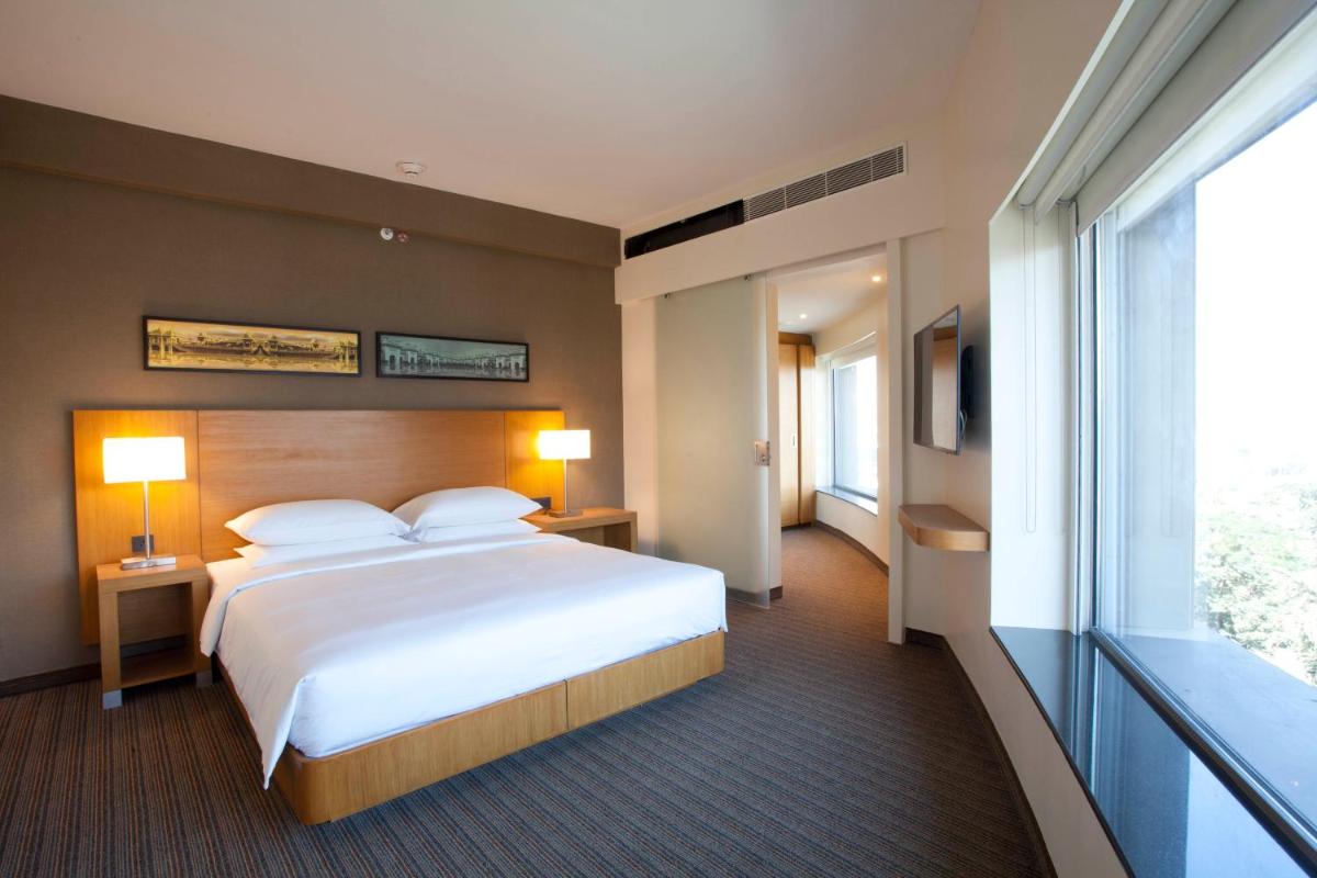 a hotel room with a bed and a large window at Hyatt Place Hyderabad Banjara Hills in Hyderabad