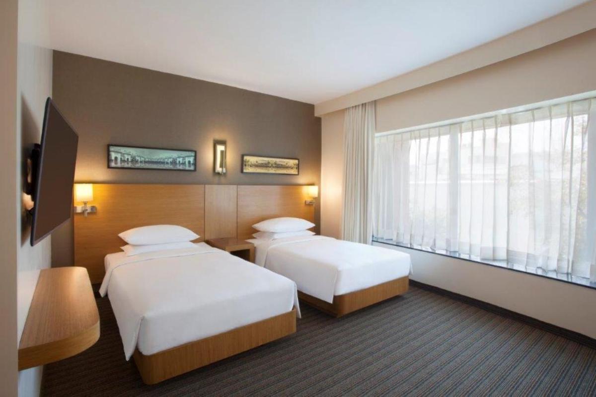 a hotel room with two beds and a window at Hyatt Place Hyderabad Banjara Hills in Hyderabad
