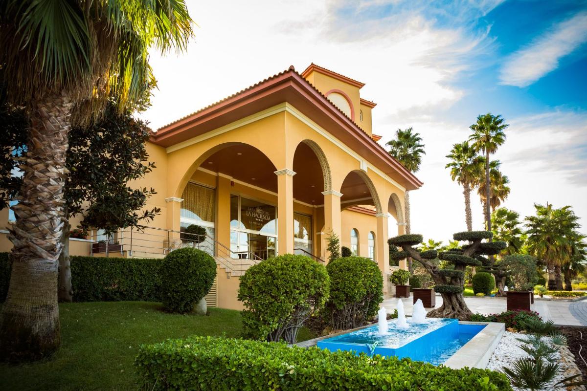 una casa con piscina delante de ella en Ohtels La Hacienda, en La Pineda