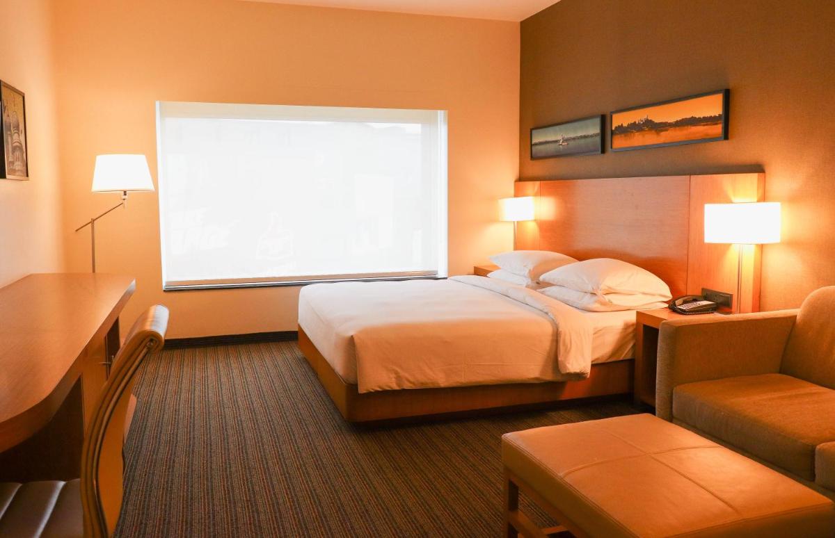 a hotel room with a bed and a window at Hyatt Place Hyderabad Banjara Hills in Hyderabad