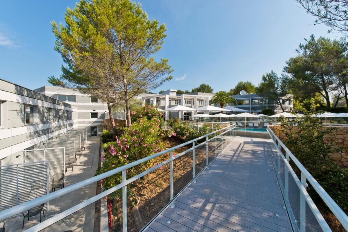 une passerelle menant à la piscine d'un complexe dans l'établissement Golden Tulip Sophia Antipolis - Hotel & Spa, à Valbonne