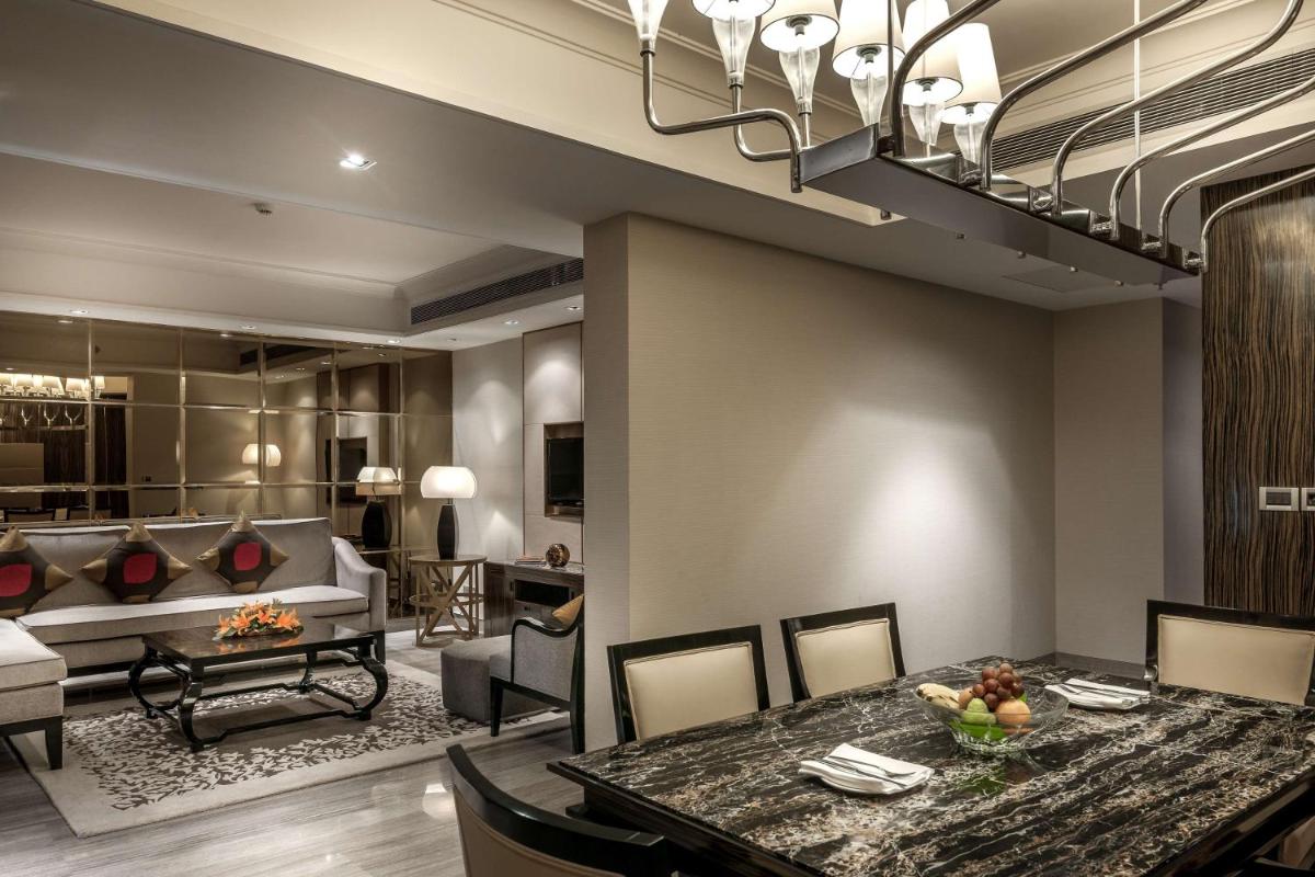 a dining room and living room with a table and a couch at Hyatt Ahmedabad in Ahmedabad