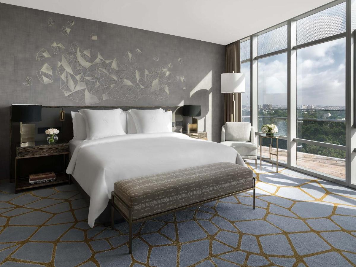 a bedroom with a large white bed and a large window at Four Seasons Hotel Bengaluru at Embassy ONE in Bengaluru a bedroom with a large white bed and a large window at Four Seasons Hotel Bengaluru at Embassy ONE in Bengaluru