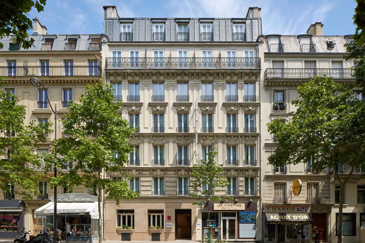 un grand bâtiment blanc avec beaucoup de fenêtres dans l'établissement Hotel Locomo - Gare de Lyon Bastille, à Paris