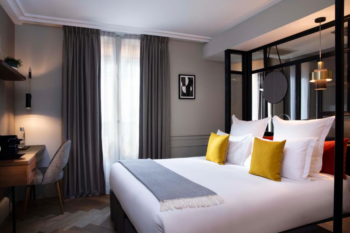 une chambre d'hôtel avec un grand lit aux oreillers jaunes dans l'établissement Maison ELLE Paris, à Paris