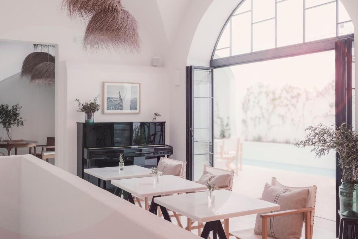 Un restaurante con mesas y sillas y un gran ventanal. en Can Araya, en Ciutadella