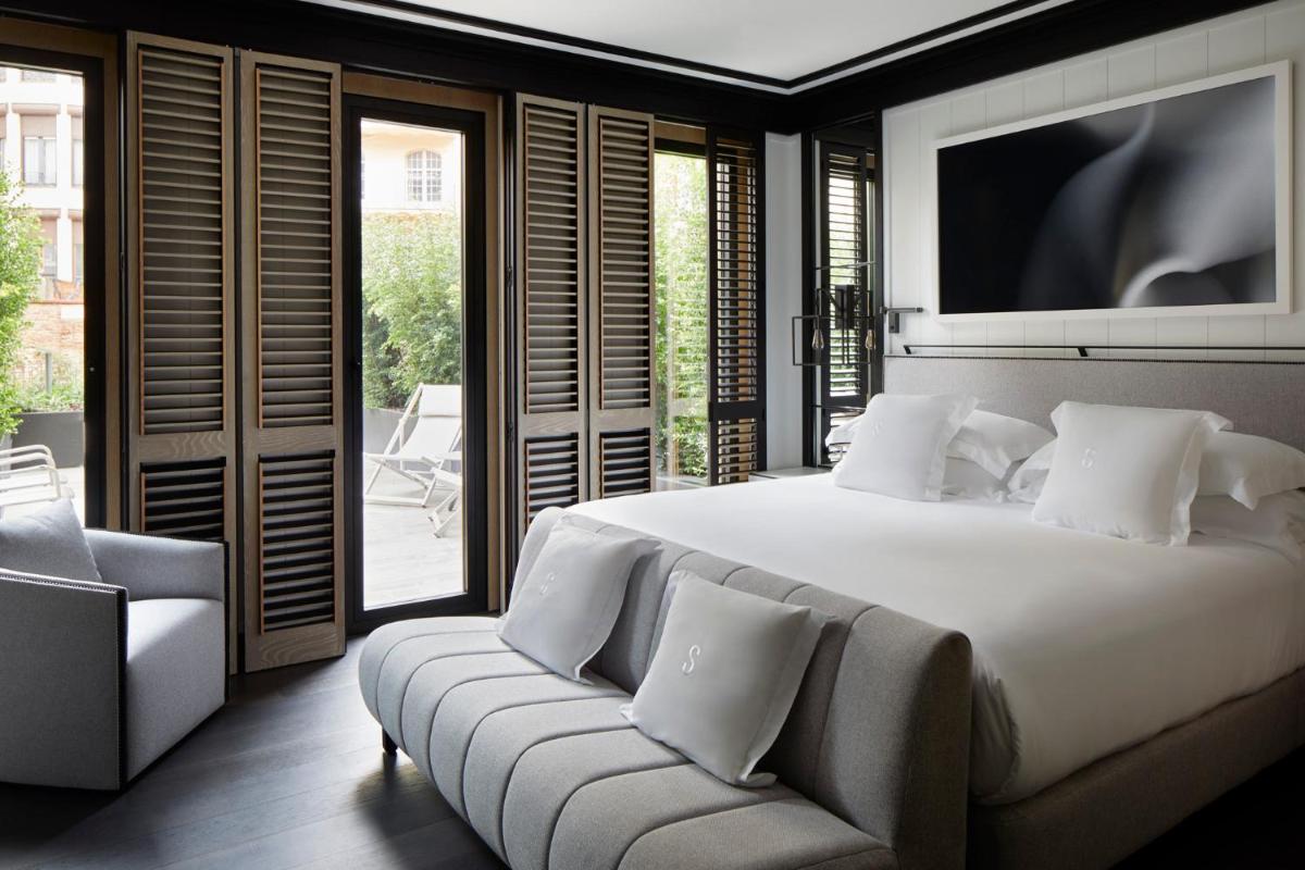 Un dormitorio con una cama, un sofá y un televisor. en Seventy Barcelona, en Barcelona