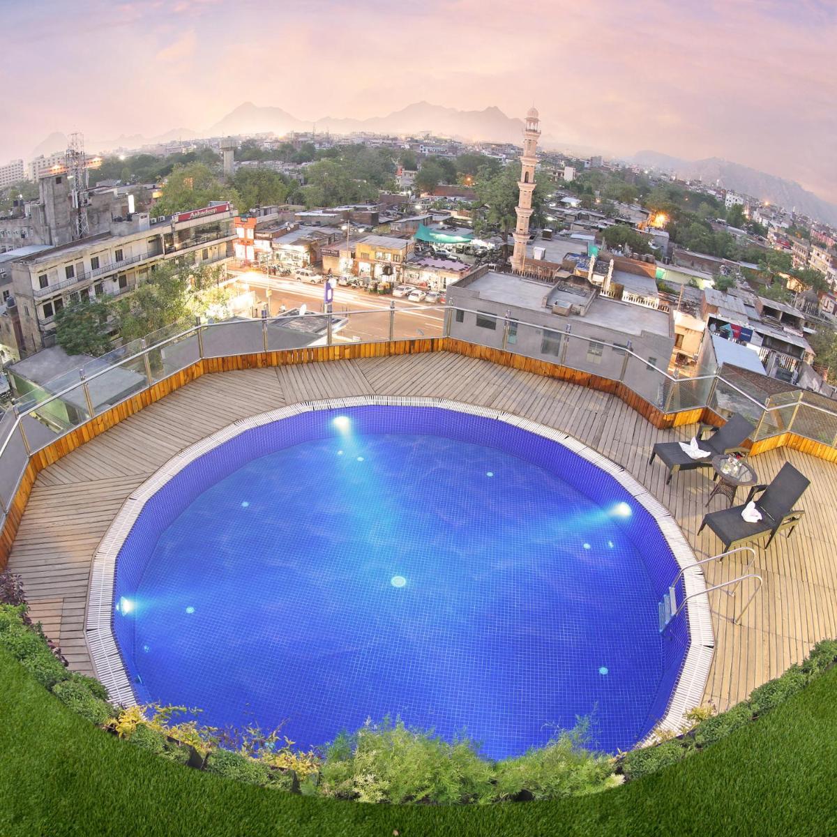 a large blue swimming pool on top of a building at Golden Tulip Jaipur in Jaipur