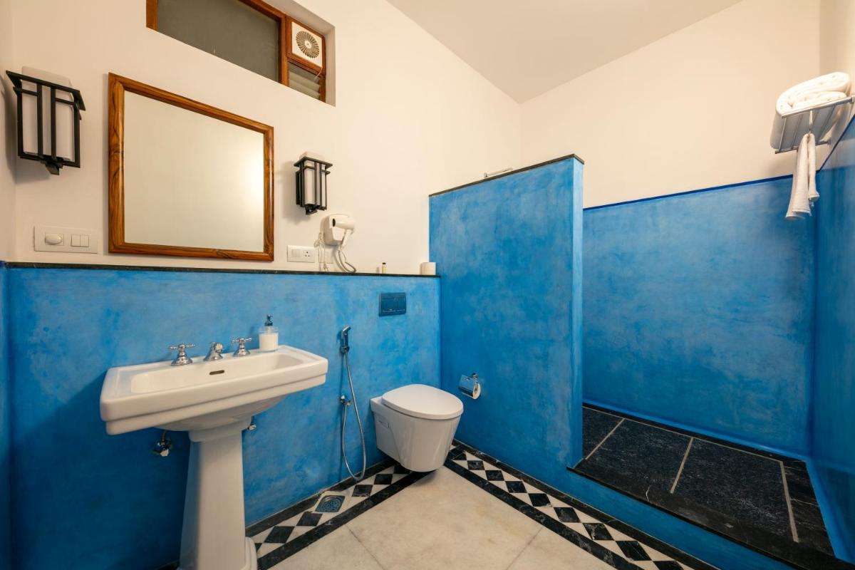 a blue bathroom with a sink and a toilet at Grand Hotel D'Europe in Puducherry