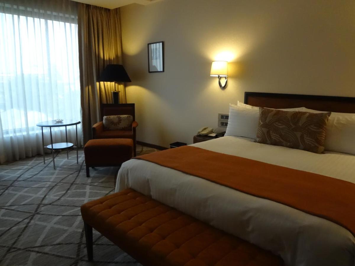 a hotel room with a large bed and a chair at Hotel Marine Plaza in Mumbai